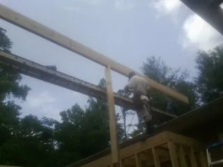 Carpenter setting a ridge beam over a new addition frame — Ice Dam Removal by Roofing Brothers in Bush