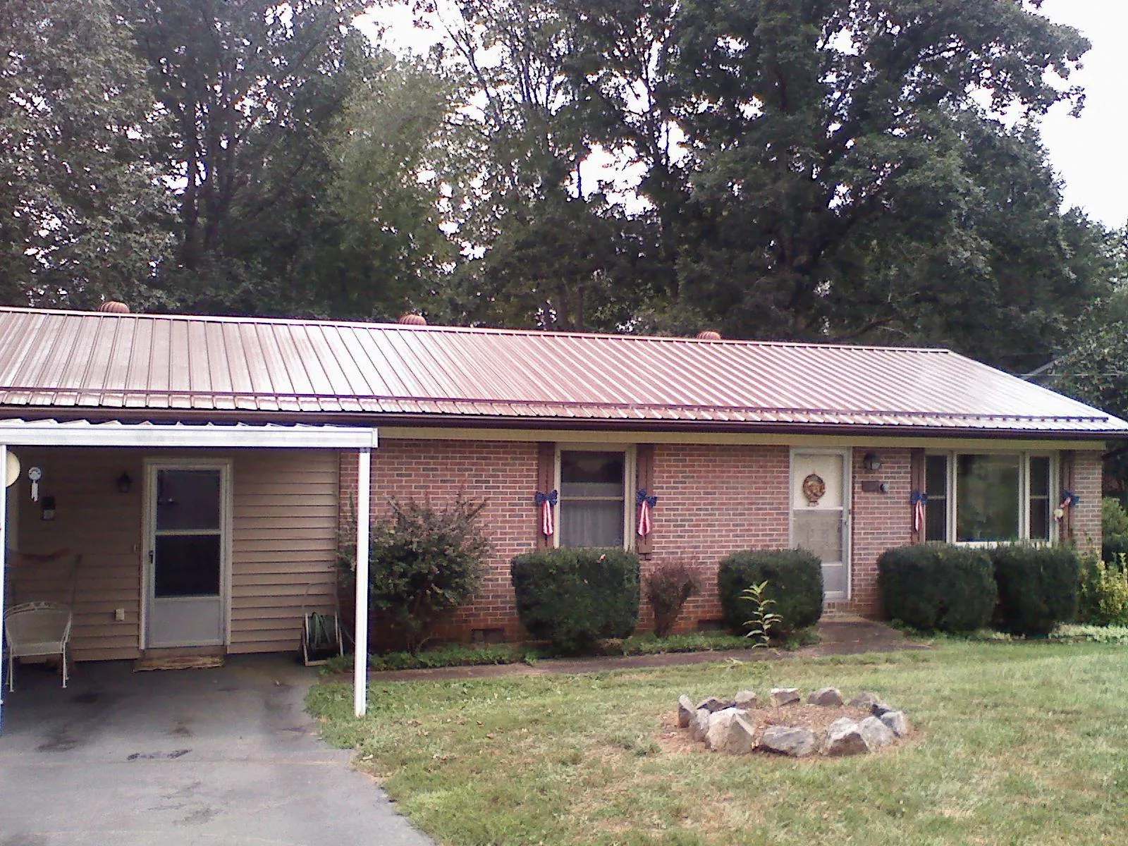 Bronze metal roof and carport on a brick ranch home — Roof Repair work by our crew in Bush